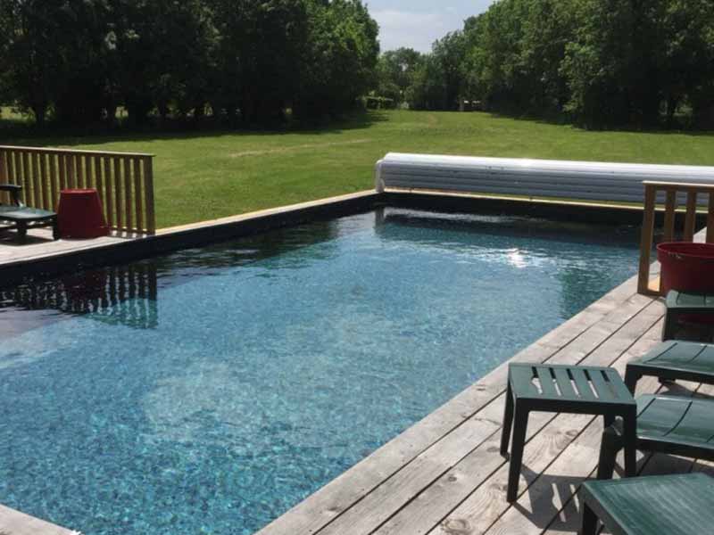 Un grand jardin avec une piscine et des espaces de jeux pour les enfants